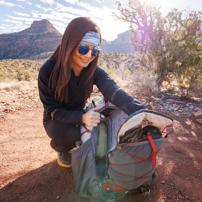 Near Zero Outdoor Gear - The Dean TR 50 Overnight Hiking Backpack - Woman reaching for things inside of backpack out in field