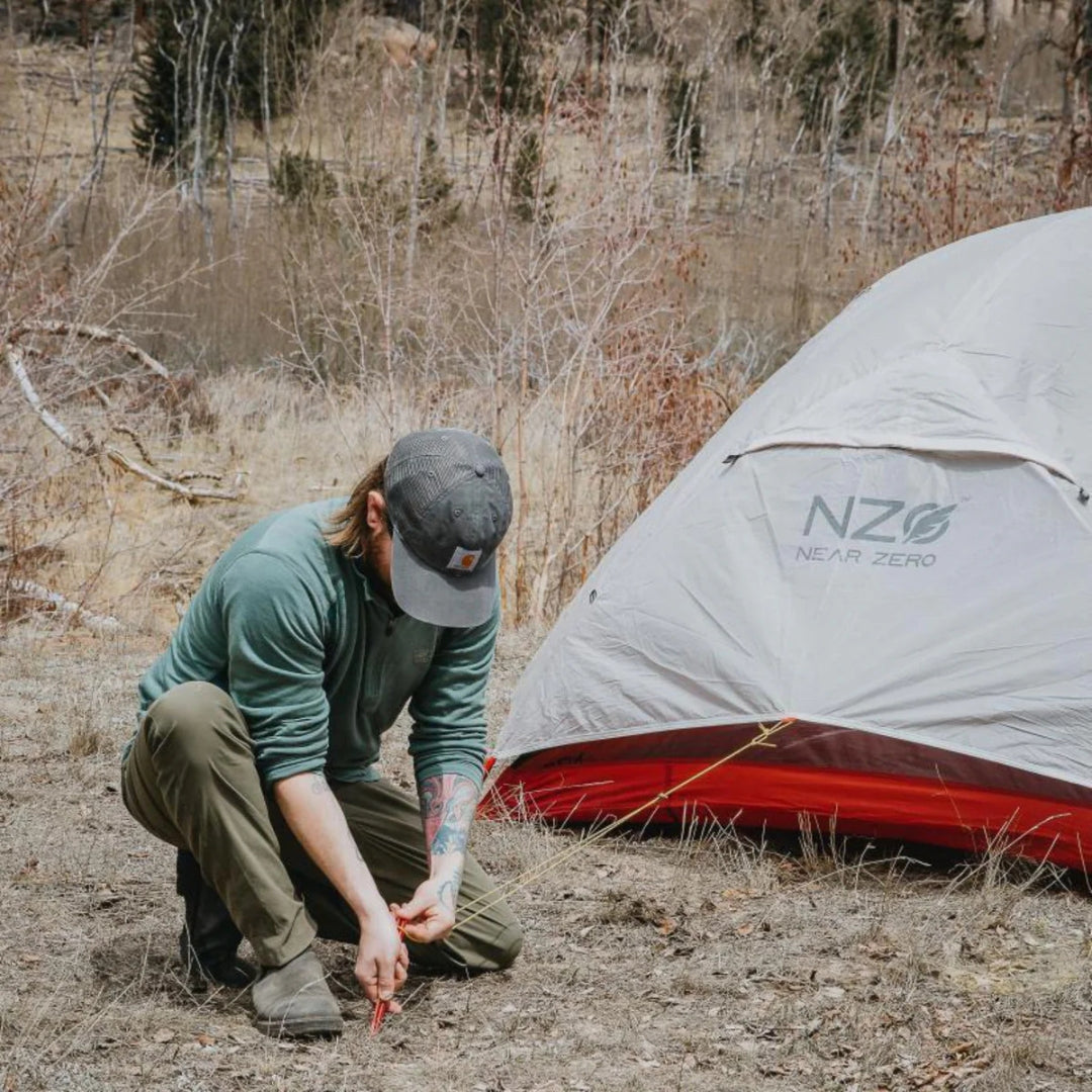 Near Zero Outdoor Gear - 3P DynaLite Tent - Man staking out tent