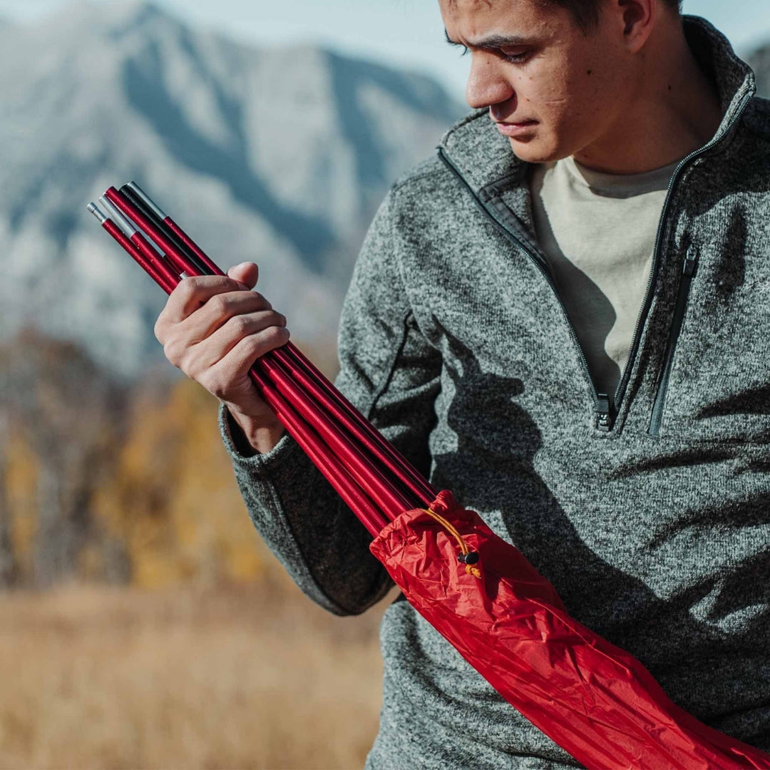 Near Zero Outdoor Gear - 2P DynaLite Tent - Man storing tent poles in stuff sack