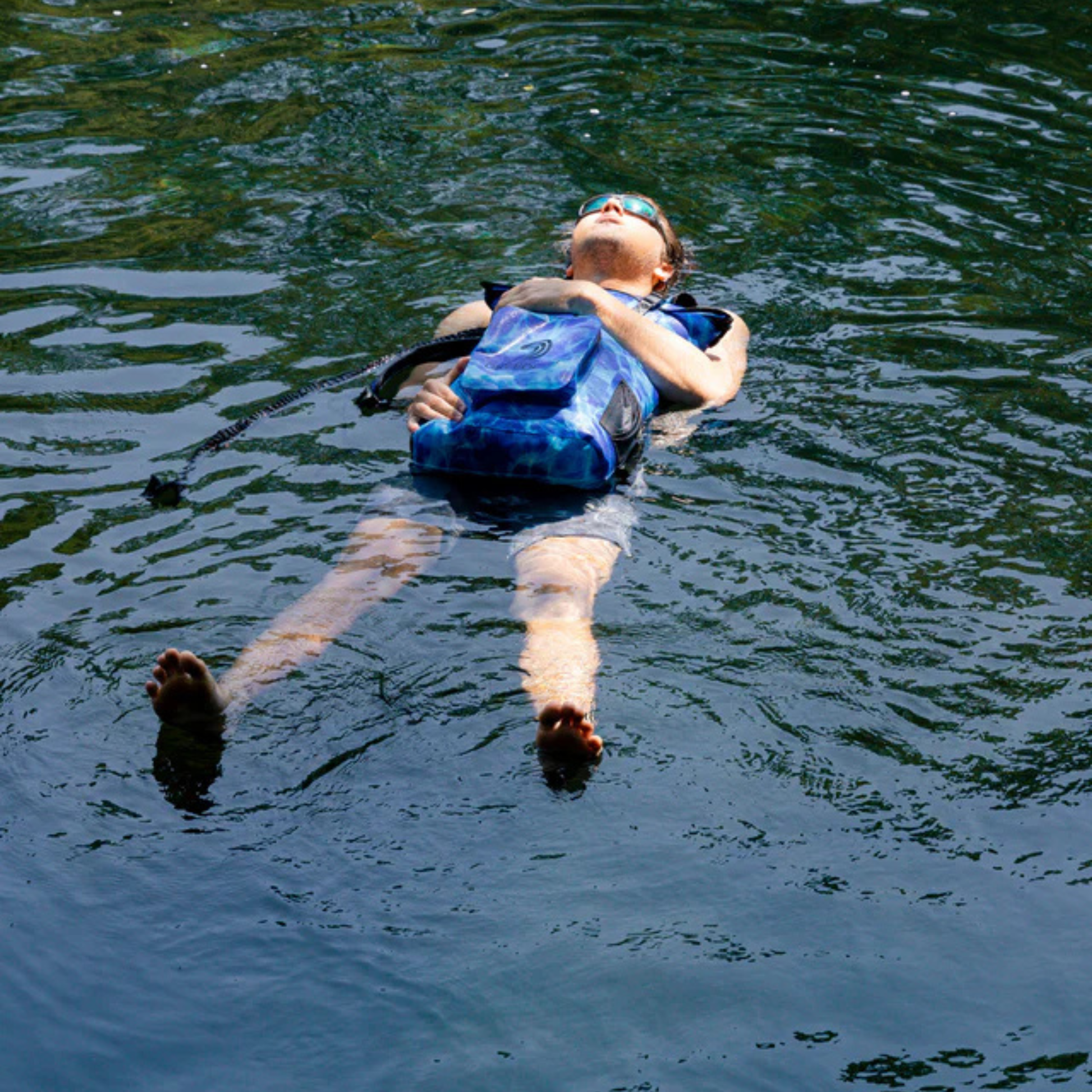 Dry Pocket - Waterproof Floating Backpack Dry Bag - Aqua Blue - Man using bag as a flotation device