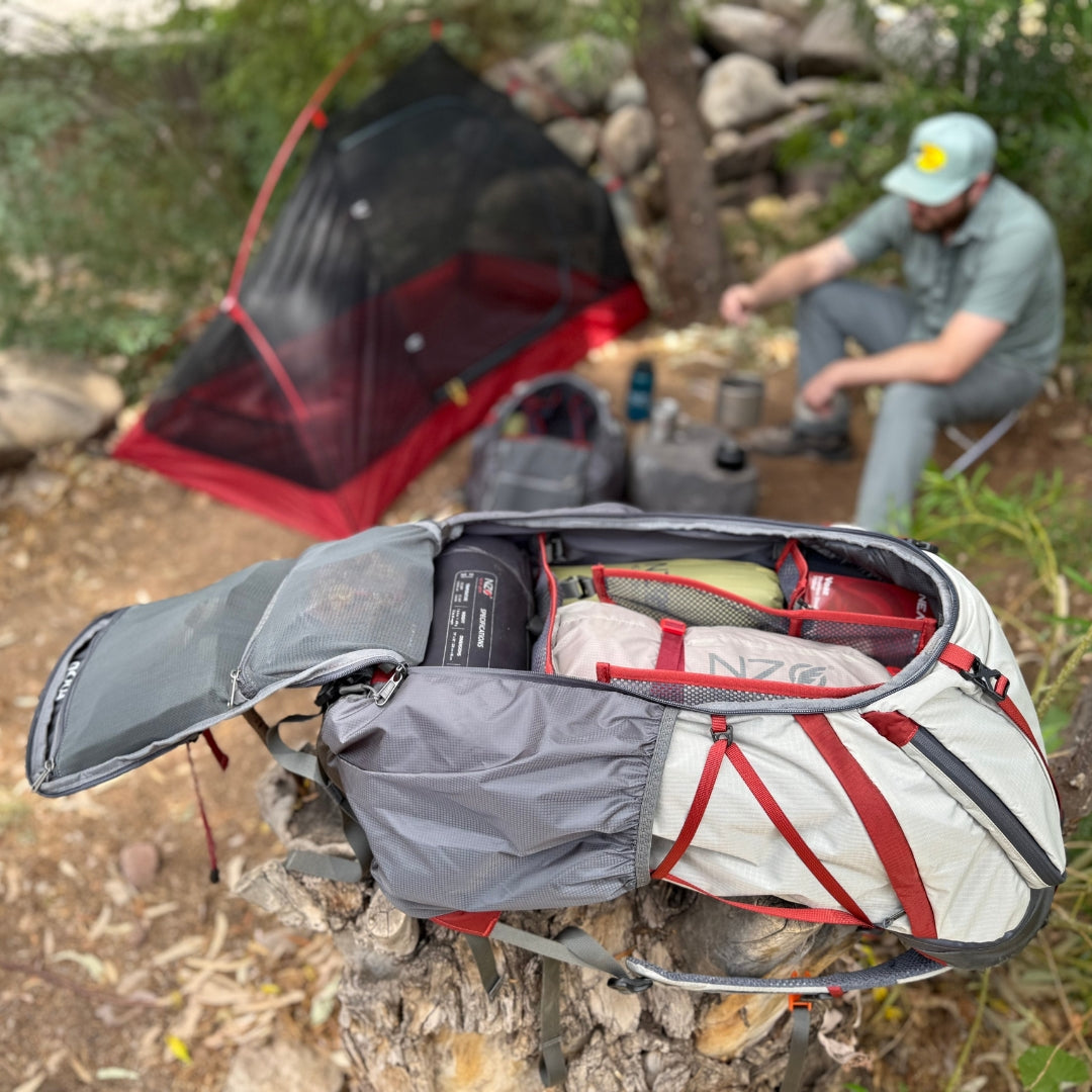 Near Zero Outdoor Gear - The Dean TR 50 Overnight Hiking Backpack - Backpack with open main compartment shown at a campsite