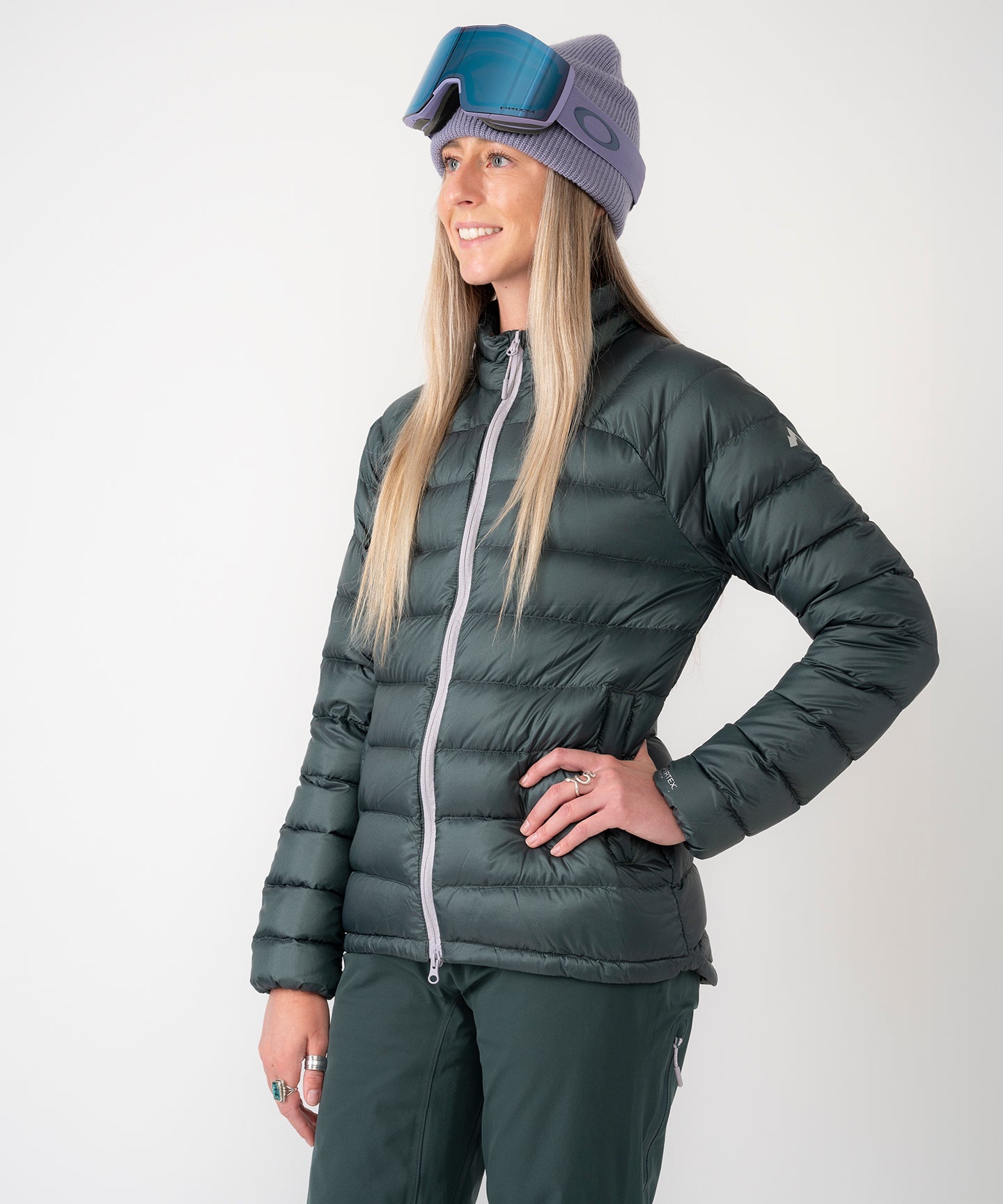 Strafe Outerwear - Palisade Down Insulator Jacket - Woman wearing puffy jacket, front left side - Deep Forest