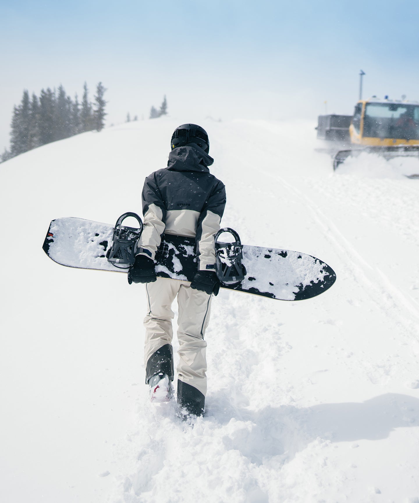Strafe Outerwear - Meadow 3L Shell Jacket - Snowboarding wearing jacket holding board, walking up a ski slope - Light Khaki