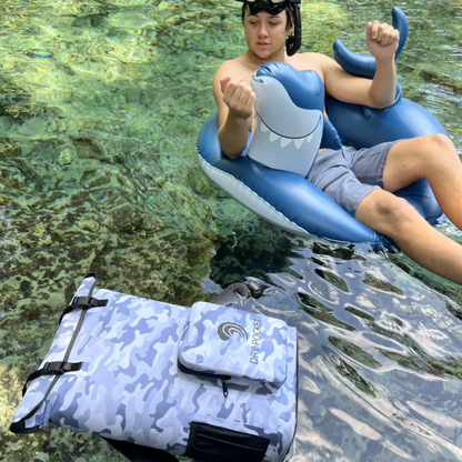 Dry Pocket - Waterproof Floating Cooler Backpack Dry Bag - Snow Camo - Floating backpack next to man floating in innertube