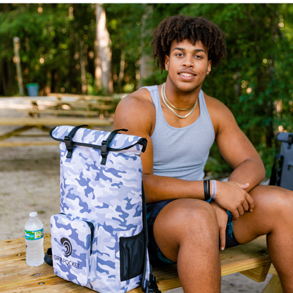 Dry Pocket - Waterproof Floating Cooler Backpack Dry Bag - Snow Camo - Man sitting with backpack